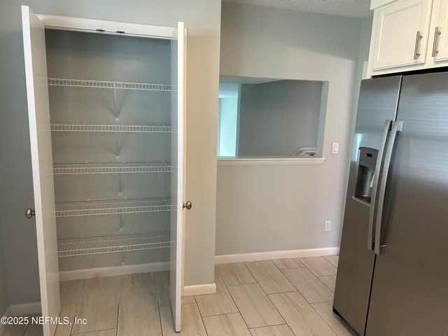 an empty room with wooden floor and hallway