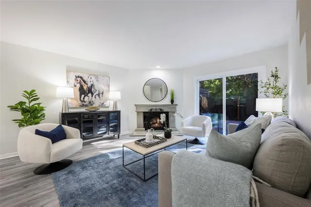 a living room with furniture a large window and a potted plant