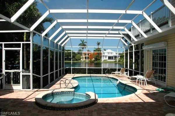 a view of a swimming pool with a dining table and chairs