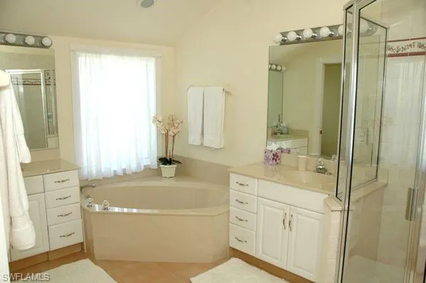 a bathroom with a tub a sink and a mirror
