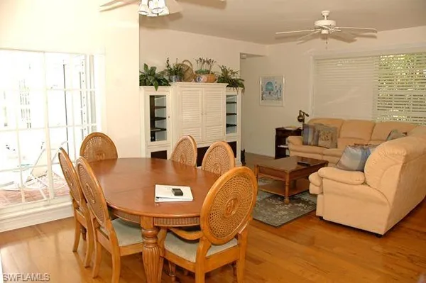 a dining room with furniture a window and wooden floor
