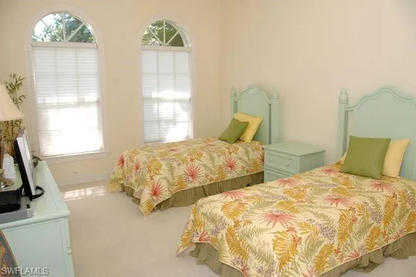 a bedroom with two beds and a window