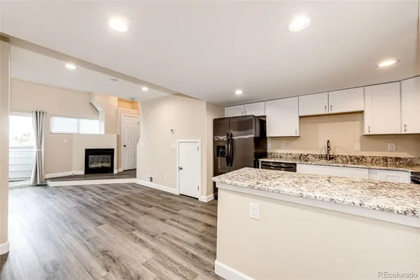 a kitchen with stainless steel appliances granite countertop a stove refrigerator sink and fireplace