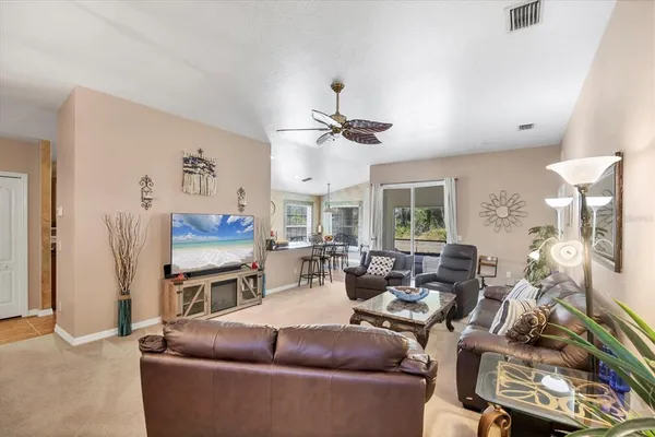 a living room with furniture ceiling fan and a window