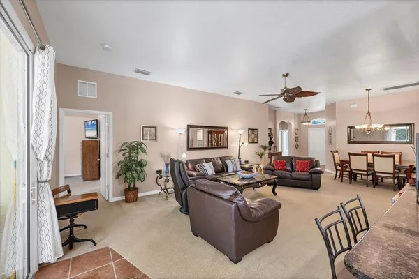 a living room with furniture ceiling fan and a flat screen tv