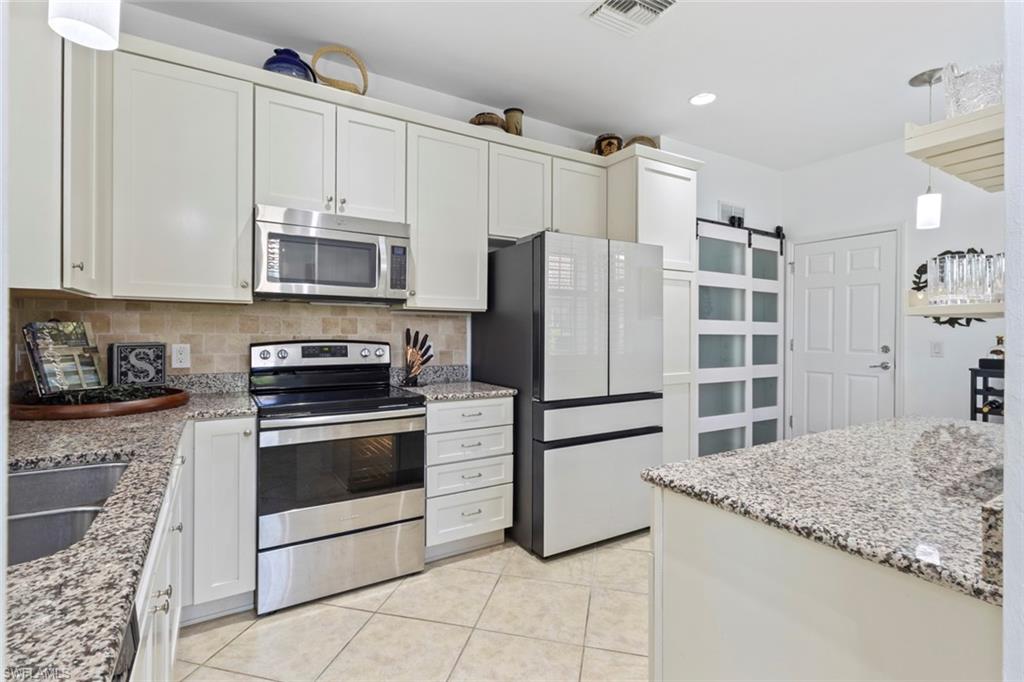 5719 Declaration Court Ave Maria, FL 34142 - Photo 5 of 48 a kitchen with stainless steel appliances granite countertop a refrigerator sink and stove