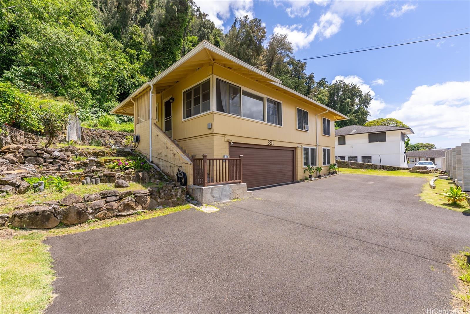 2811 Henry Street Honolulu, HI 96817 - Photo 1 of 25 Welcome home to this sunny, cheerful yellow beauty! A spacious driveway leads to a large, secure garage, all perfectly nestled against a lush, tropical hillside.