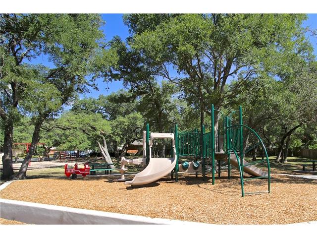 7006 Rambollet Terrace Round Rock, TX 78681 - Photo 33 of 38 A well-maintained community playground awaits, surrounded by mature trees for shaded recreation.