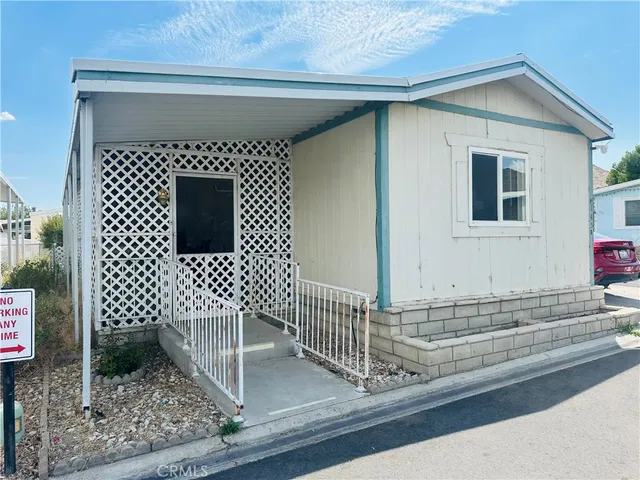 a view of a house with a small yard and wooden floor and fence