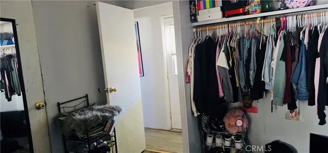 a view of walk in closet with clothes and shoes