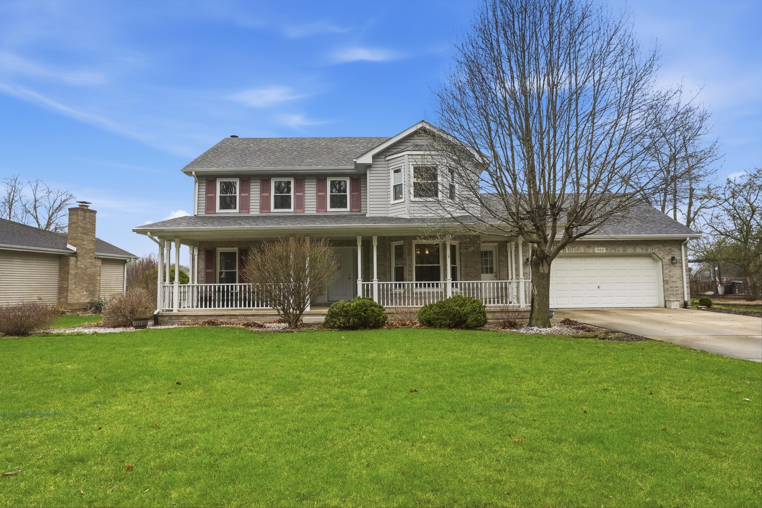 a front view of a house with a garden and yard