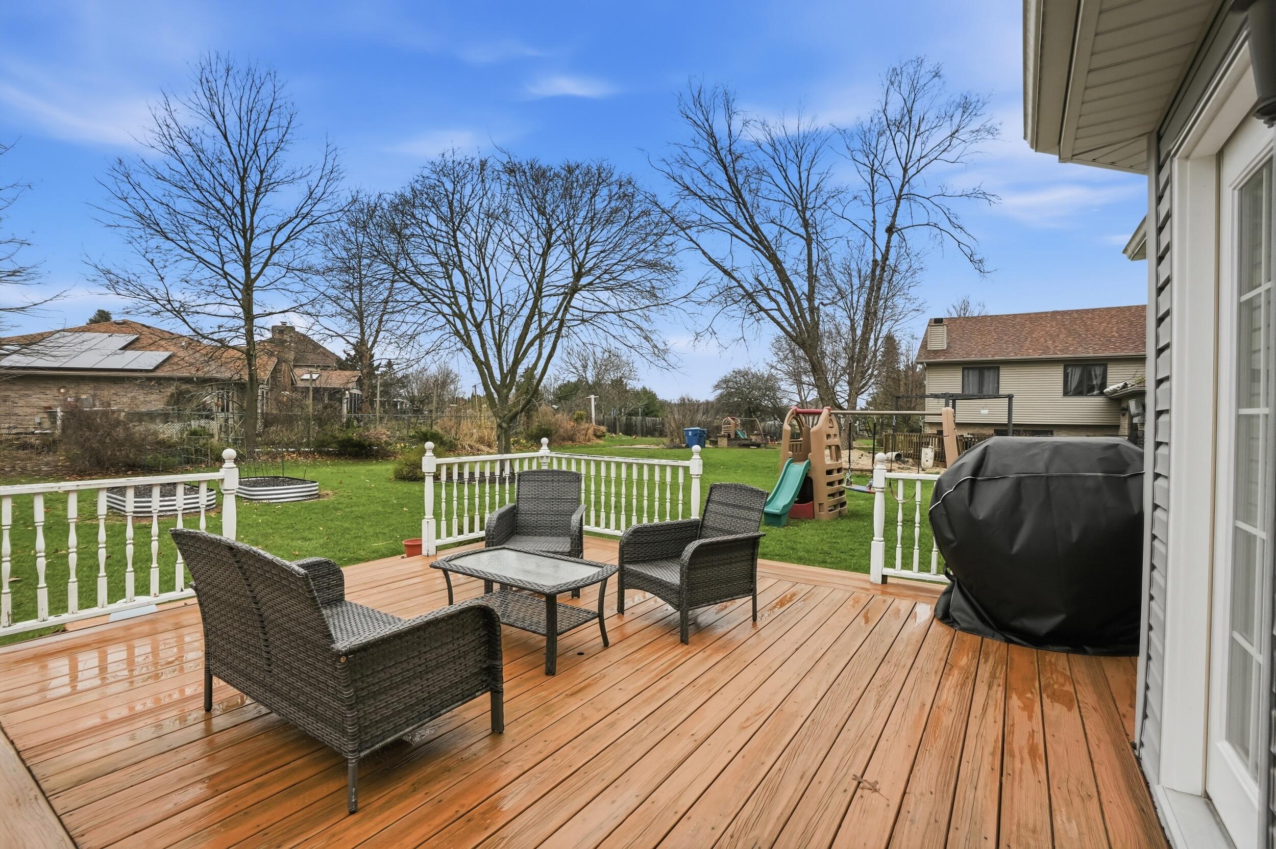 1122 Douglas Lane Crete, IL 60417 - Photo 25 of 28 a view of a deck with couches table and chairs and wooden floor