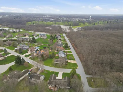 an aerial view of a house with a mountain