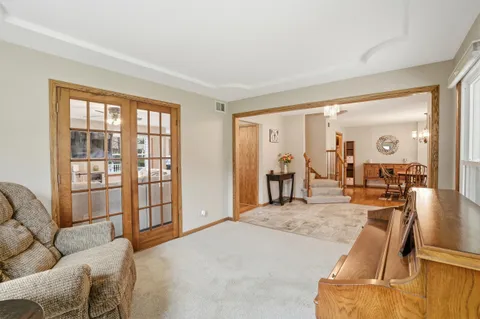 a kitchen with stainless steel appliances granite countertop a stove top oven a sink dishwasher a dining table and chairs with wooden floor