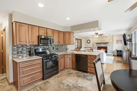 a kitchen with a dining table chairs stainless steel appliances cabinets and a sink
