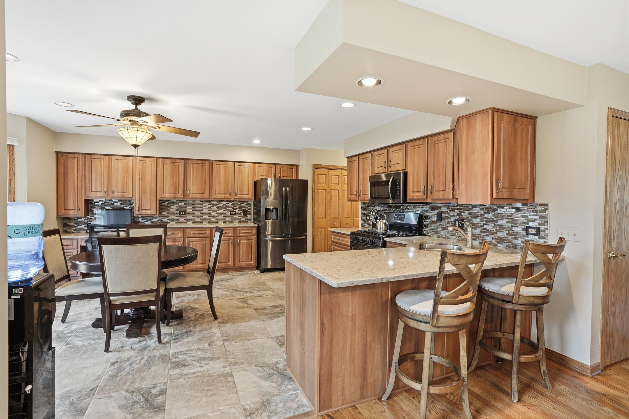 1122 Douglas Lane Crete, IL 60417 - Photo 8 of 28 a kitchen with a dining table chairs stainless steel appliances cabinets and a sink