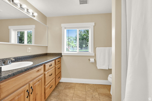 13658 South Fort Street Draper, UT 84020 - Photo 47 of 87 Bathroom featuring a light wood-finish vanity with a built-in sink, dark speckled countertop, and brushed nickel hardware