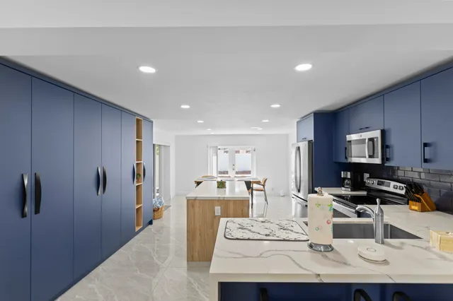 a large living room with stainless steel appliances furniture