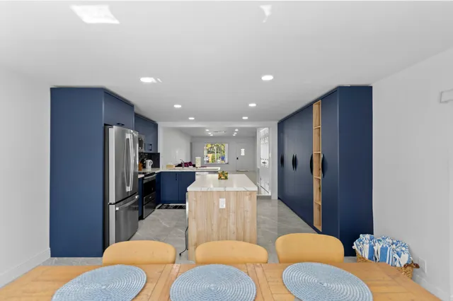 a kitchen with stainless steel appliances granite countertop a stove refrigerator and a refrigerator