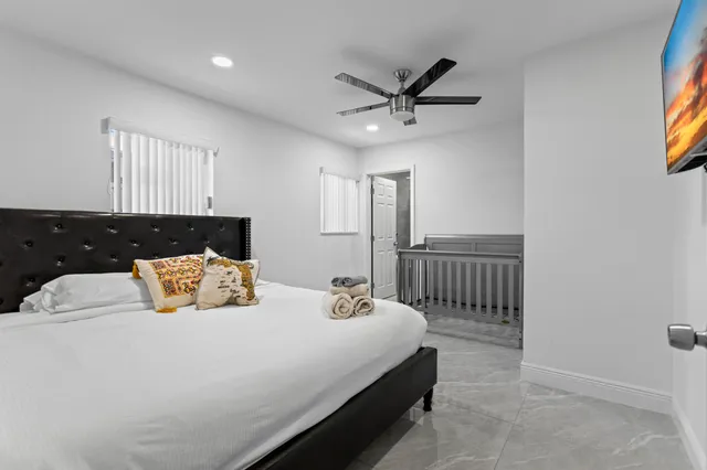 a bed sitting in a bedroom next to a window with a chandelier