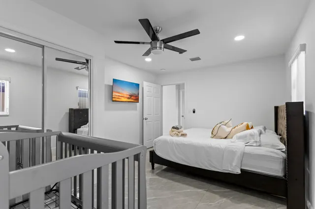 a bedroom with a bed and a ceiling fan