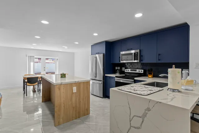 a kitchen that has a lot of cabinets in it and stainless steel appliances