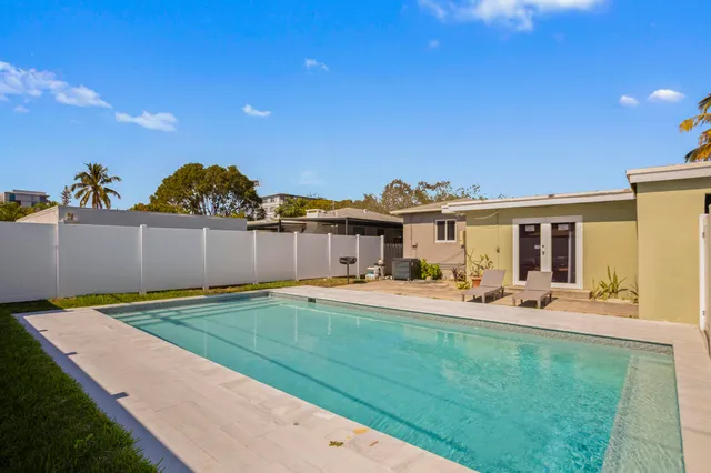 a view of an empty room with furniture and a window