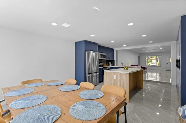 a kitchen with refrigerator and chairs