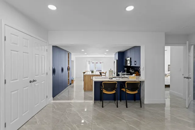 a dining room with furniture and a floor to ceiling window