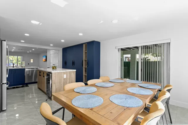 a kitchen with stainless steel appliances granite countertop a refrigerator a sink dishwasher a stove and a refrigerator with wooden floor