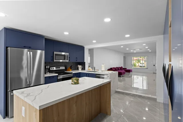 a living room with stainless steel appliances kitchen island granite countertop furniture and a view of kitchen