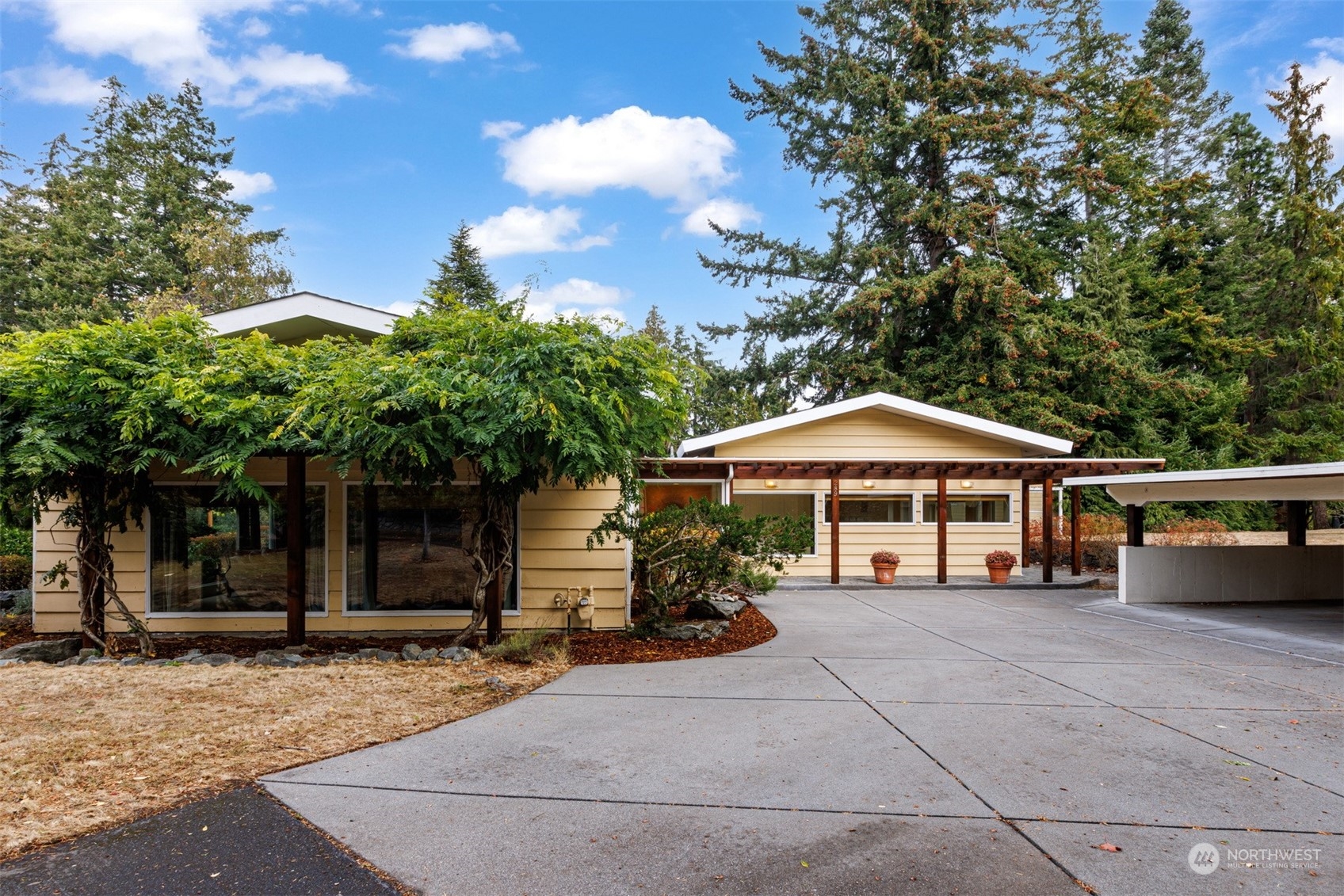 a view of a house with backyard and sitting area
