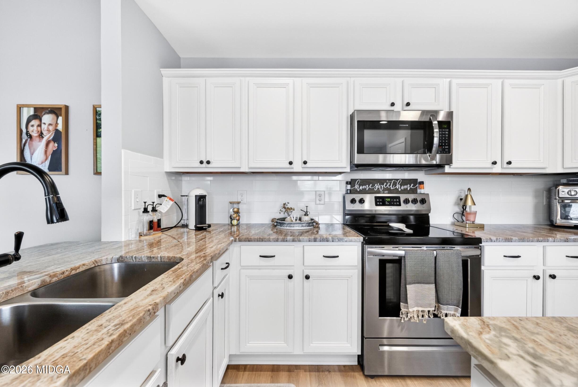 610 Daisy Drive Perry, GA 31069 - Photo 11 of 33 a kitchen with stainless steel appliances granite countertop a sink a stove and cabinets