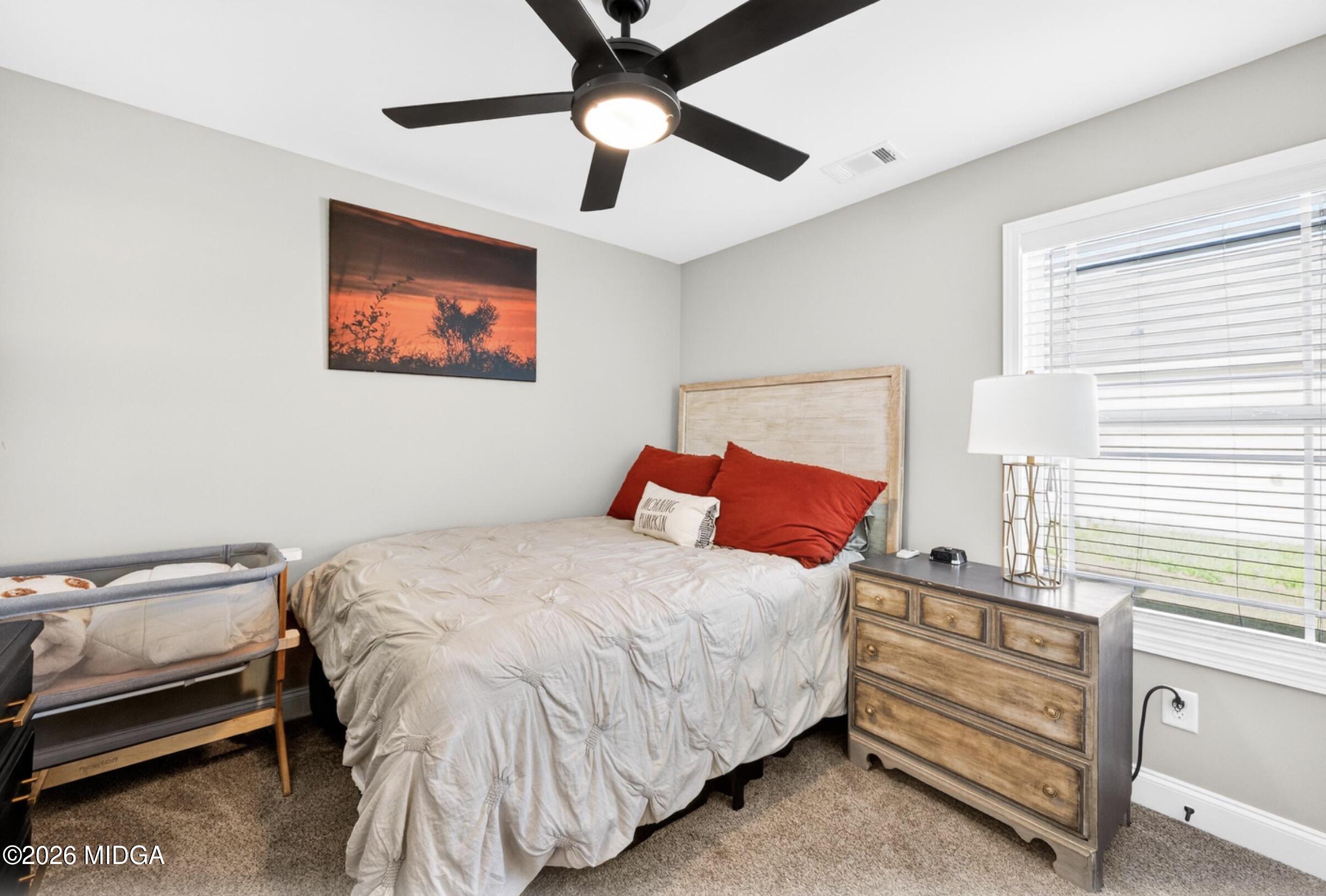 610 Daisy Drive Perry, GA 31069 - Photo 22 of 33 a bedroom with a bed and a chandelier