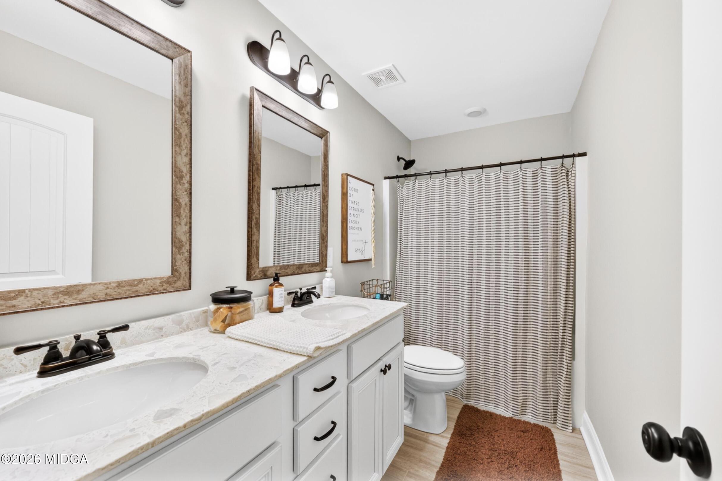 610 Daisy Drive Perry, GA 31069 - Photo 25 of 33 a bathroom with a double vanity sink toilet and mirror
