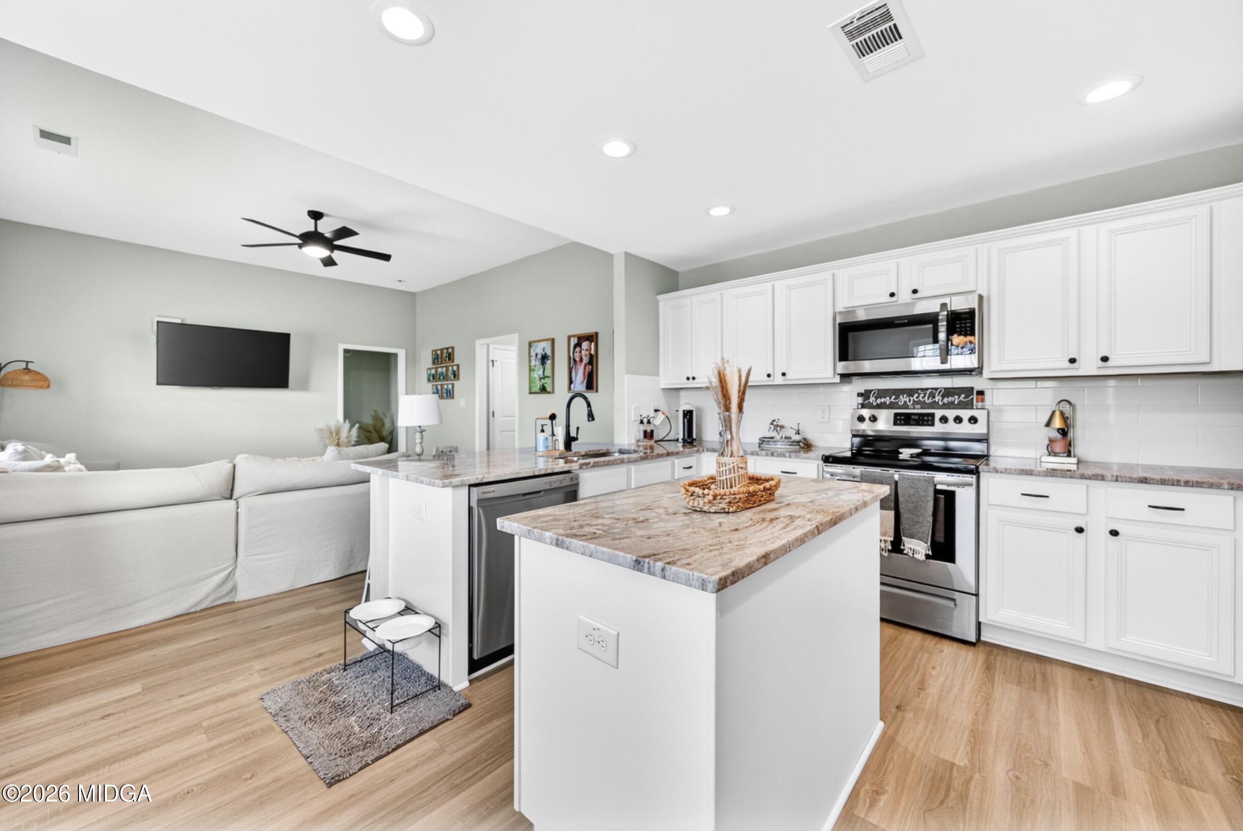 610 Daisy Drive Perry, GA 31069 - Photo 9 of 33 a kitchen with granite countertop a stove top oven a sink dishwasher and a refrigerator with wooden floor