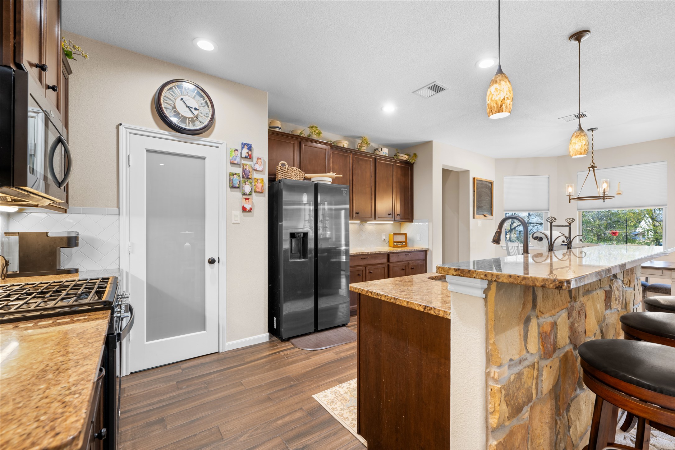 9467 Loop Road Bellville, TX 77418 - Photo 10 of 26 a kitchen with granite countertop a refrigerator a stove and white cabinets