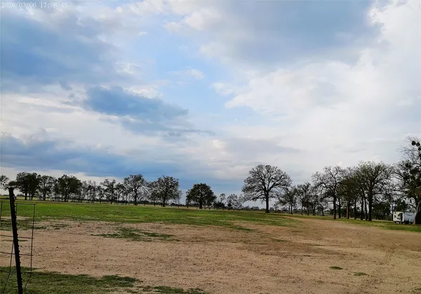 a view of a field with houses in back