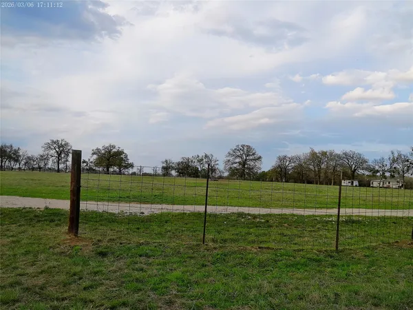 a view of a field and trees in the background