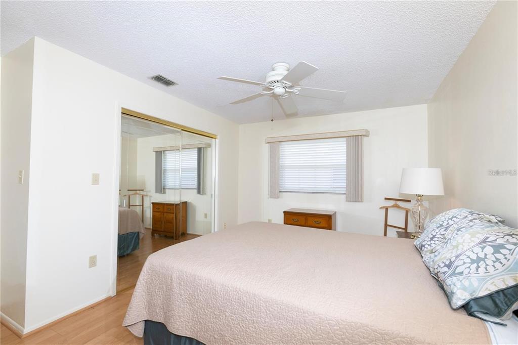 4932 Ilener Street New Port Richey, FL 34652 - Photo 14 of 38 a bedroom with a large bed and a chandelier