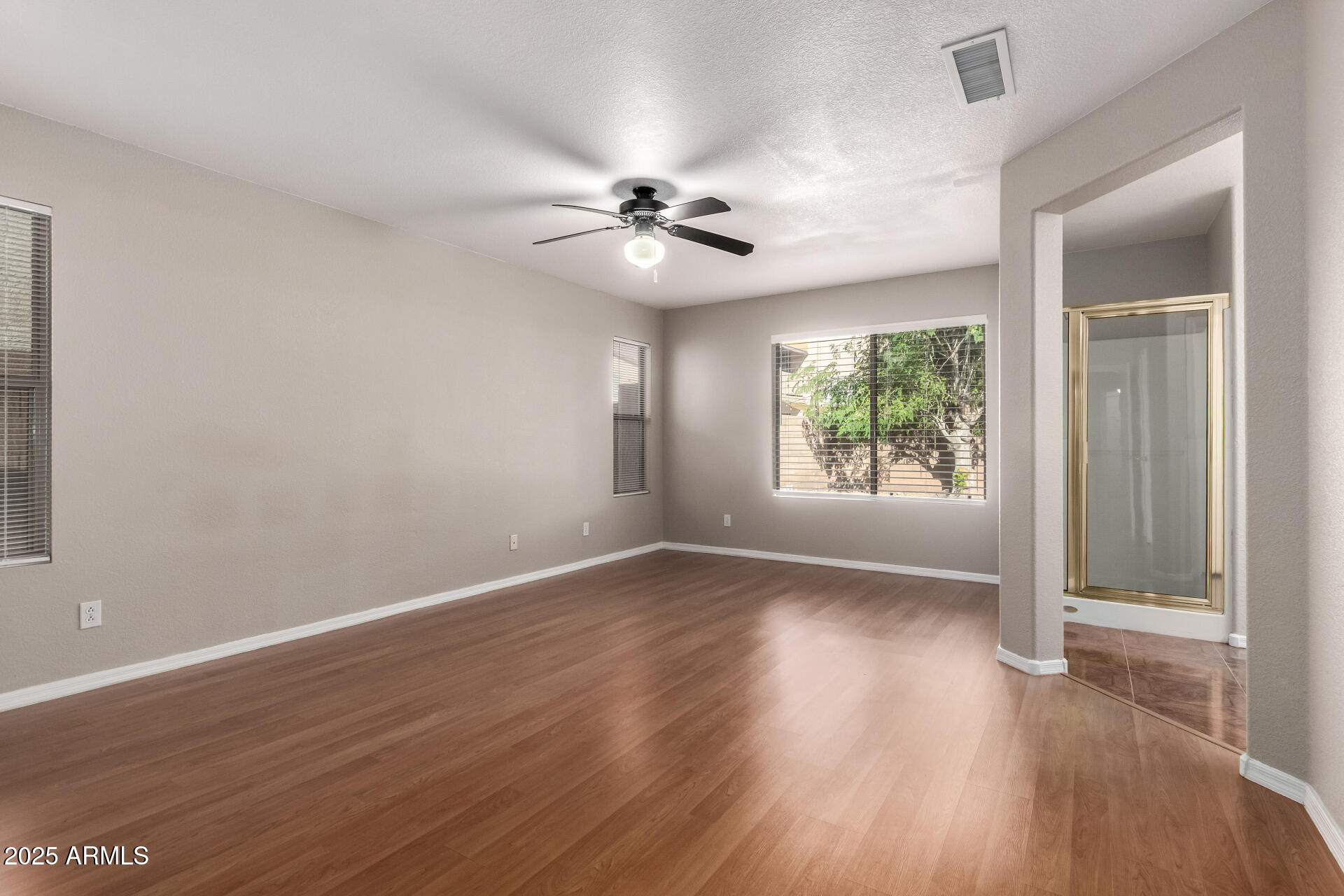 3822 West Fallen Leaf Lane Glendale, AZ 85310 - Photo 14 of 35 an empty room with wooden floor chandelier fan and windows