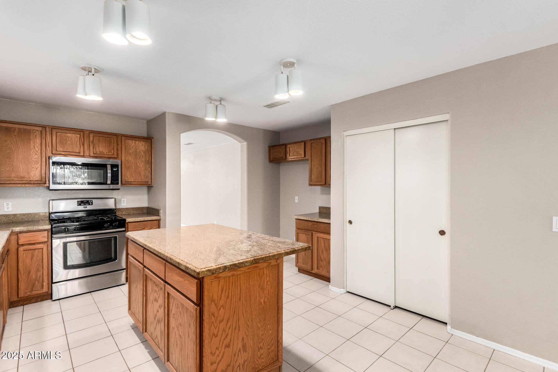 3822 West Fallen Leaf Lane Glendale, AZ 85310 - Photo 10 of 35 a kitchen with stainless steel appliances granite countertop a stove a sink and a refrigerator