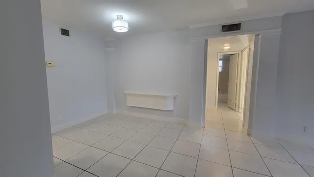 an empty room with white walls and glass door