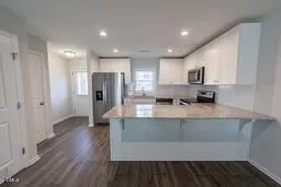 a view of kitchen with stainless steel appliances granite countertop a refrigerator and a stove top oven