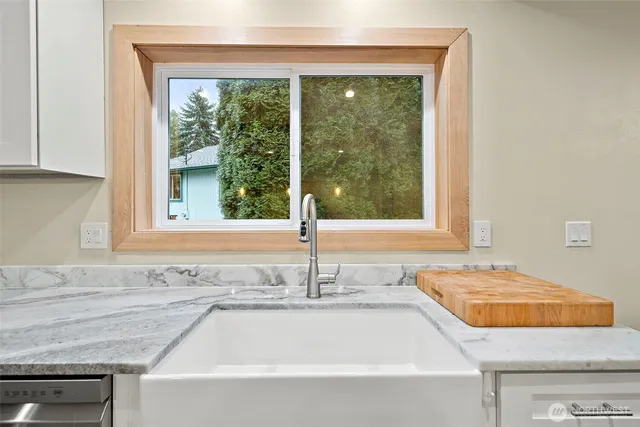 a bathroom with a granite countertop sink and a window