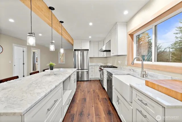 a large kitchen with kitchen island a large counter space a sink appliances and cabinets