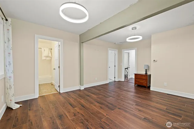 an empty room with wooden floor and mirror
