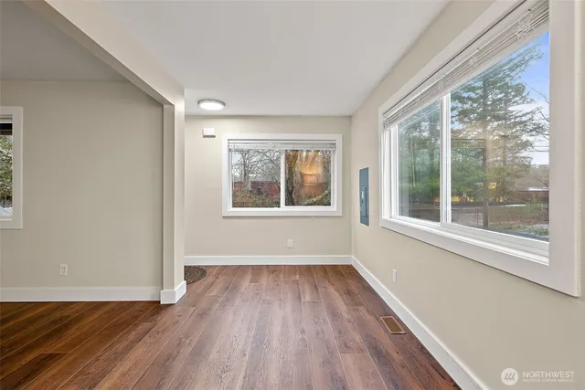 a view of empty room with window and wooden floor