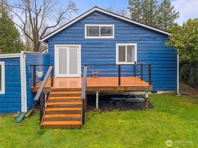 a backyard of a house with barbeque and wooden fence