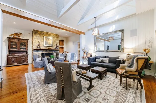 a living room with stainless steel appliances kitchen island granite countertop furniture and wooden floors